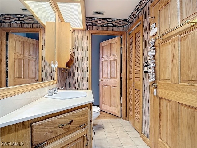 bathroom featuring toilet, tile patterned floors, visible vents, and vanity