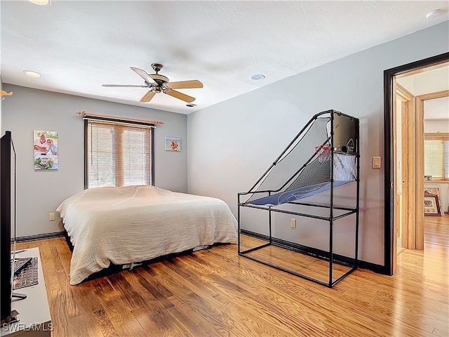 bedroom featuring ceiling fan, wood finished floors, and baseboards