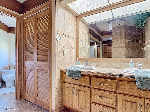 bathroom with a closet, a sink, tile walls, and toilet