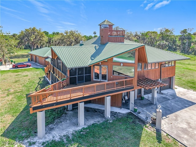 exterior space with metal roof, an attached garage, concrete driveway, a yard, and a standing seam roof