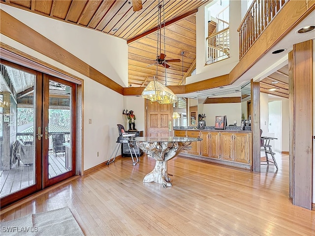 dining area featuring french doors, ceiling fan, high vaulted ceiling, light wood-type flooring, and baseboards