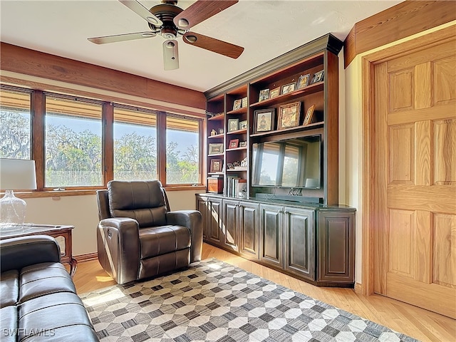 interior space featuring light wood-style flooring, baseboards, and ceiling fan