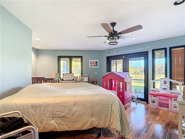 bedroom featuring access to exterior, wood-type flooring, and a ceiling fan
