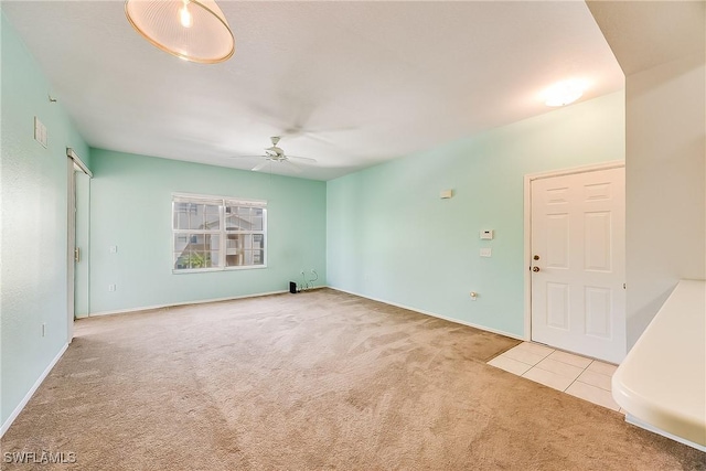 spare room with tile patterned flooring, carpet flooring, and a ceiling fan
