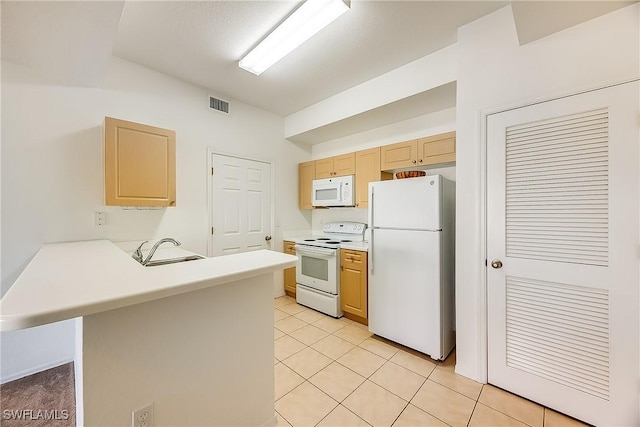 kitchen featuring light brown cabinetry, light countertops, a peninsula, white appliances, and a sink