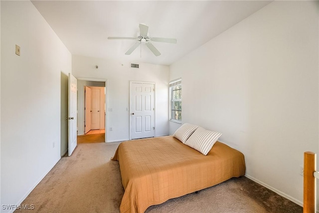 carpeted bedroom with visible vents, baseboards, and a ceiling fan