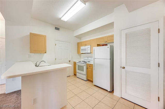 kitchen with visible vents, light brown cabinets, white appliances, a peninsula, and light countertops