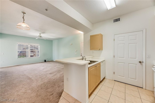 kitchen with visible vents, a peninsula, white dishwasher, a sink, and light colored carpet