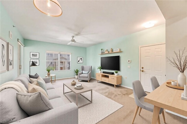 living area featuring visible vents, light colored carpet, baseboards, and a ceiling fan