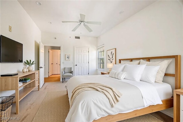 bedroom with visible vents, light carpet, and a ceiling fan