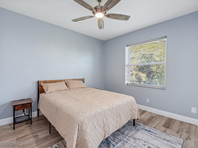 bedroom featuring wood finished floors and baseboards