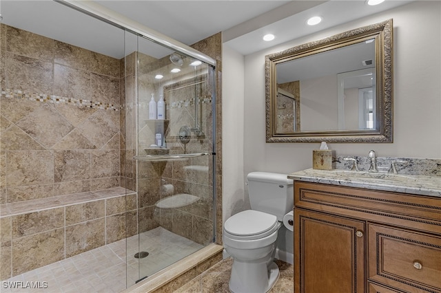 full bathroom featuring a shower stall, baseboards, vanity, and toilet