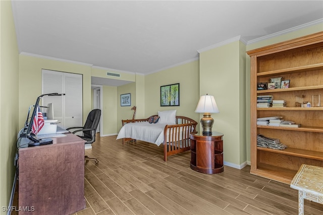 bedroom featuring visible vents, baseboards, and wood finished floors