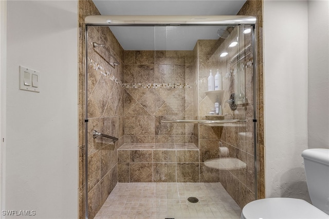 bathroom featuring a stall shower and toilet