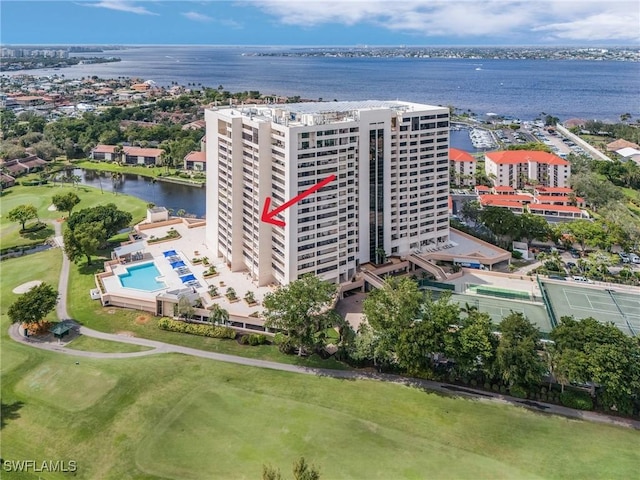 drone / aerial view with view of golf course and a water view