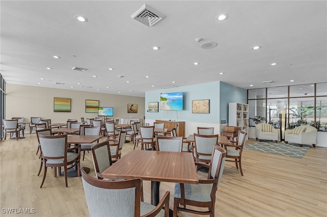 dining area with light wood-style flooring, visible vents, and recessed lighting