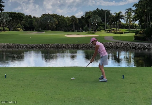 surrounding community featuring view of golf course, a lawn, and a water view