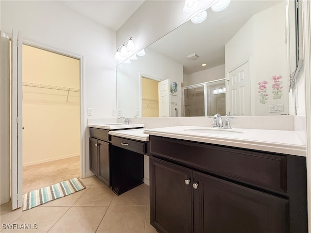 bathroom with a stall shower, tile patterned flooring, two vanities, and a sink