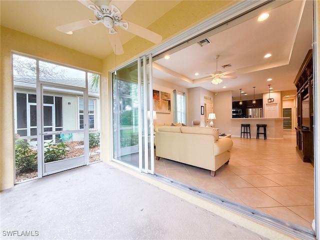 unfurnished living room featuring light tile patterned flooring, a raised ceiling, visible vents, and recessed lighting