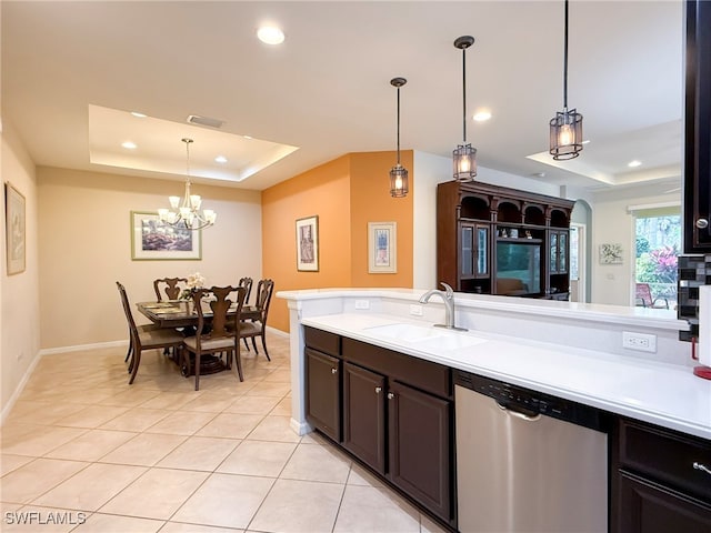 kitchen with a tray ceiling, recessed lighting, light countertops, a sink, and dishwasher