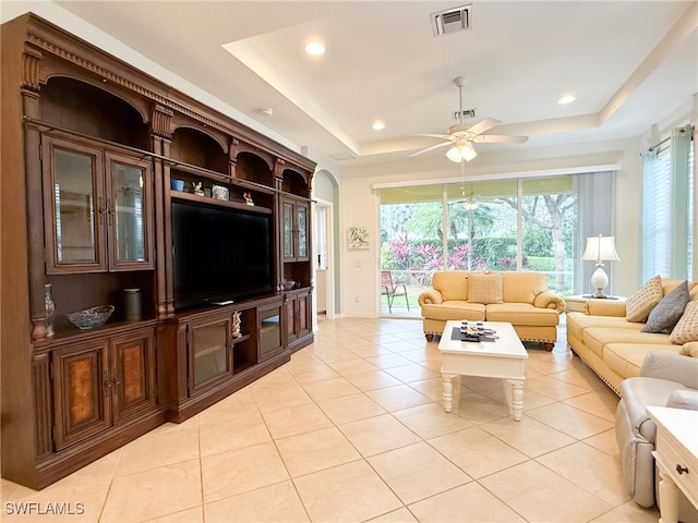 living area with a tray ceiling, visible vents, recessed lighting, and light tile patterned floors