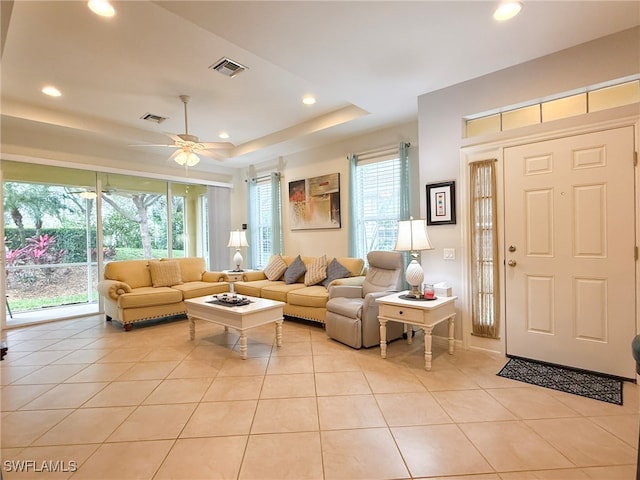 living room featuring recessed lighting, a raised ceiling, visible vents, and light tile patterned floors