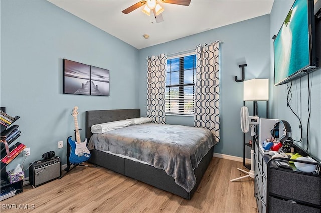 bedroom with a ceiling fan, baseboards, and wood finished floors