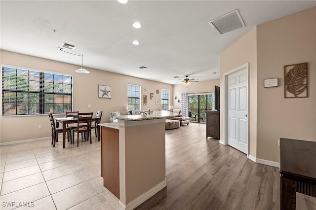 kitchen with light stone countertops, baseboards, and visible vents