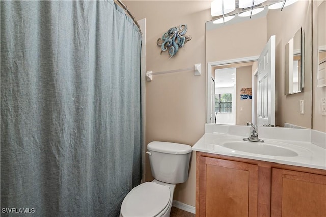 bathroom with curtained shower, vanity, and toilet