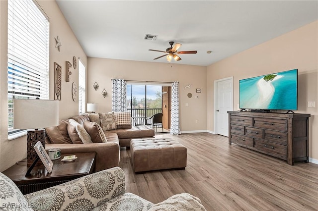 living room with a ceiling fan, baseboards, visible vents, and wood finished floors