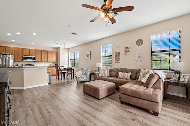 living area featuring recessed lighting, a ceiling fan, baseboards, visible vents, and light wood finished floors