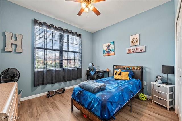 bedroom with ceiling fan, baseboards, and wood finished floors