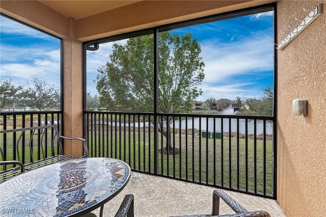 sunroom / solarium featuring a water view