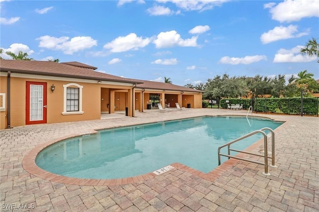 community pool featuring a patio area and fence