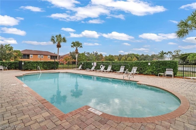 community pool featuring fence and a patio