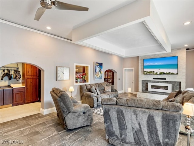 living room with arched walkways, recessed lighting, and baseboards