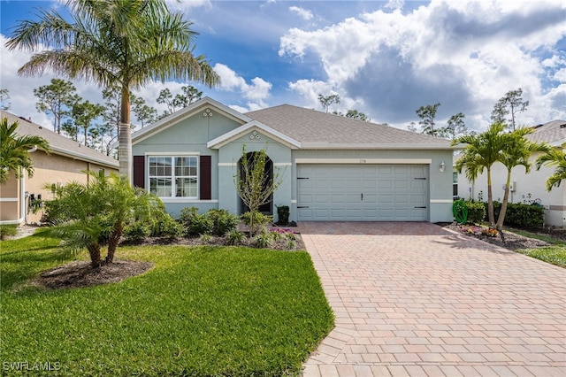 ranch-style house with a front lawn, decorative driveway, an attached garage, and stucco siding