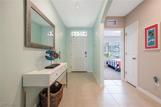 foyer featuring light tile patterned floors, baseboards, and visible vents