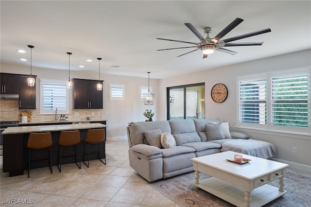 living area featuring light tile patterned floors, baseboards, a ceiling fan, and recessed lighting