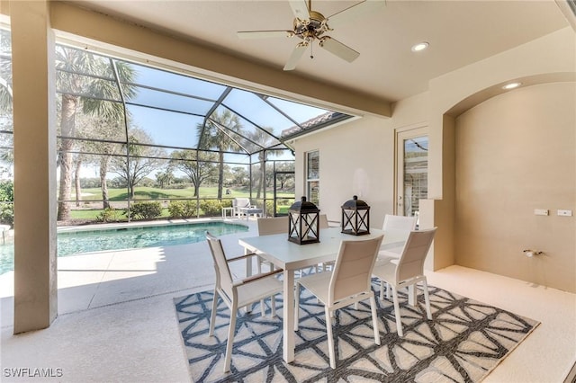 view of patio with a lanai, outdoor dining area, ceiling fan, and an outdoor pool