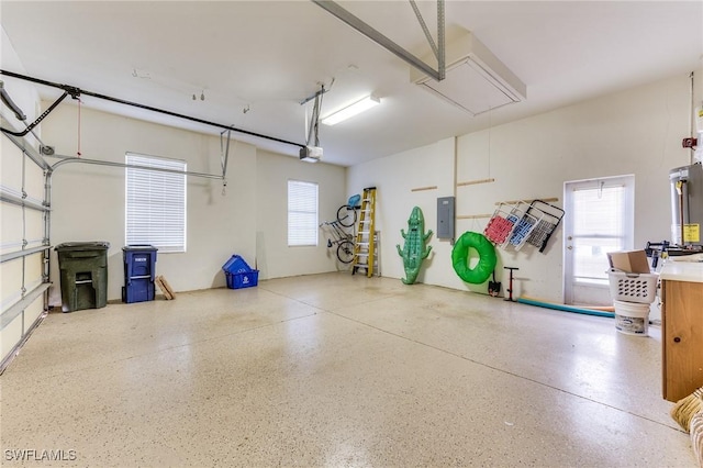 garage with a garage door opener, gas water heater, and electric panel