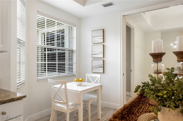 dining area with baseboards, visible vents, and light wood-style floors