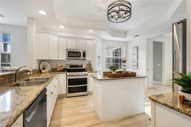 kitchen with stone countertops, an inviting chandelier, a sink, and stainless steel appliances