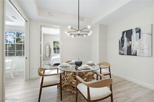 dining room featuring a wealth of natural light, visible vents, light wood-style floors, and a chandelier