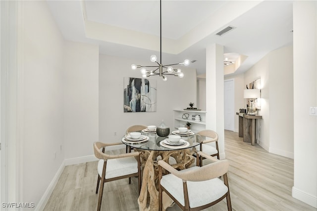 dining area featuring baseboards, visible vents, light wood-style flooring, and an inviting chandelier