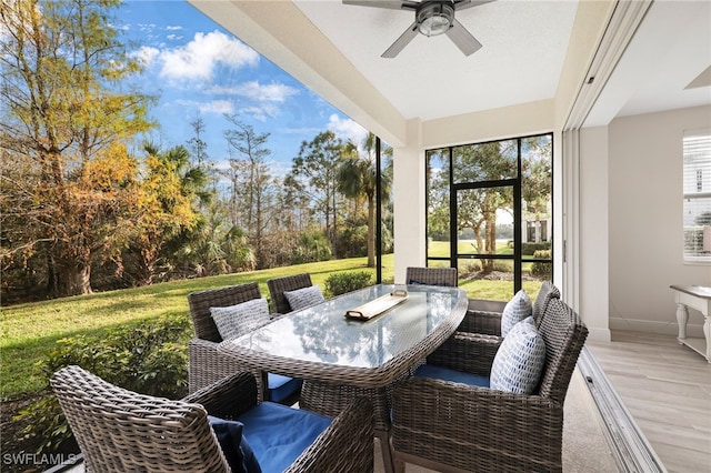 sunroom featuring outdoor dining space and ceiling fan