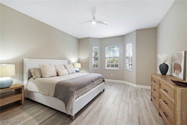 bedroom with baseboards, ceiling fan, and light wood-type flooring