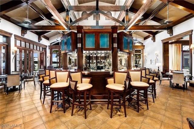 bar featuring wet bar, high vaulted ceiling, light tile patterned flooring, beam ceiling, and a ceiling fan