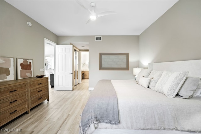 bedroom with a ceiling fan, ensuite bathroom, light wood finished floors, and visible vents