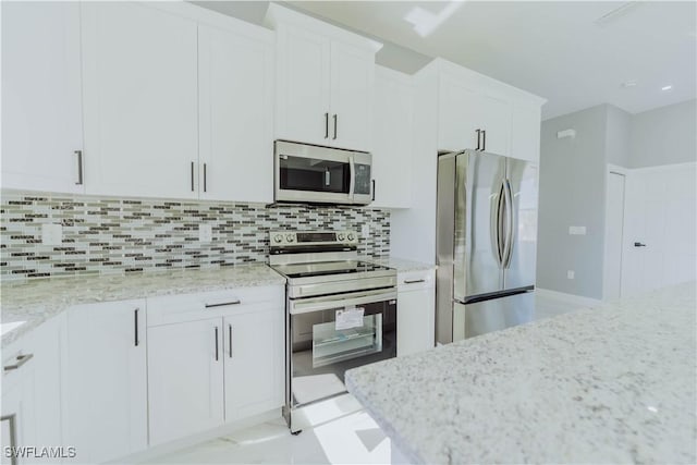 kitchen with white cabinetry, light stone counters, tasteful backsplash, and appliances with stainless steel finishes